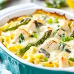 Creamy Chicken and Asparagus Casserole baked with mushrooms, noodles, and golden cheese in a teal ceramic dish