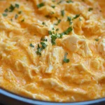 Creamy Crockpot Buffalo Chicken Dip topped with fresh parsley in a serving bowl.