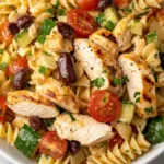 Close-up of Mediterranean Chicken Pasta Salad with rotini, grilled chicken, tomatoes, cucumbers, and olives