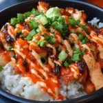 Close-up of a Bang Bang Chicken Bowl with crispy chicken, white rice, spicy mayo, and green onions