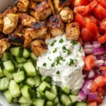 Grilled chicken gyro bowls with tzatziki, cucumbers, tomatoes, and red onions.