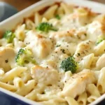 Chicken and Broccoli Alfredo Bake served in a white casserole dish, topped with melted cheese and broccoli florets.