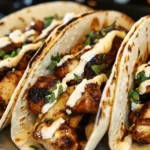 Garlic Butter Honey BBQ Chicken Tacos filled with juicy grilled chicken, drizzled with creamy sauce and topped with fresh cilantro.