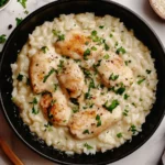 One Pan Creamy Parmesan Chicken and Rice in a black skillet garnished with parsley