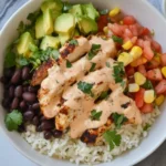 Southwest Chicken Burrito Bowls with grilled chicken, black beans, avocado, corn salsa, and creamy dressing over cilantro lime rice.