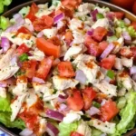 Fresh and colorful BLT Chicken Salad with tomatoes, red onions, and crisp lettuce in a bowl