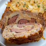 Sliced Chicken Cordon Bleu Meatloaf showing layers of ham, Swiss cheese, and seasoned ground chicken