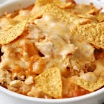 Baked Doritos Chicken Casserole with melted cheese and crunchy tortilla chips in a white round dish.