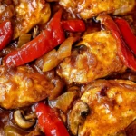 Braised Catalina Chicken with red bell peppers, onions, and mushrooms in a rich, tangy sauce.