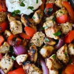 Grilled Blackstone Greek Chicken and Peppers with red onions and bell peppers served with creamy yogurt sauce