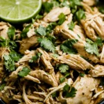 Slow Cooker Cilantro Lime Chicken shredded and garnished with fresh cilantro in a bowl