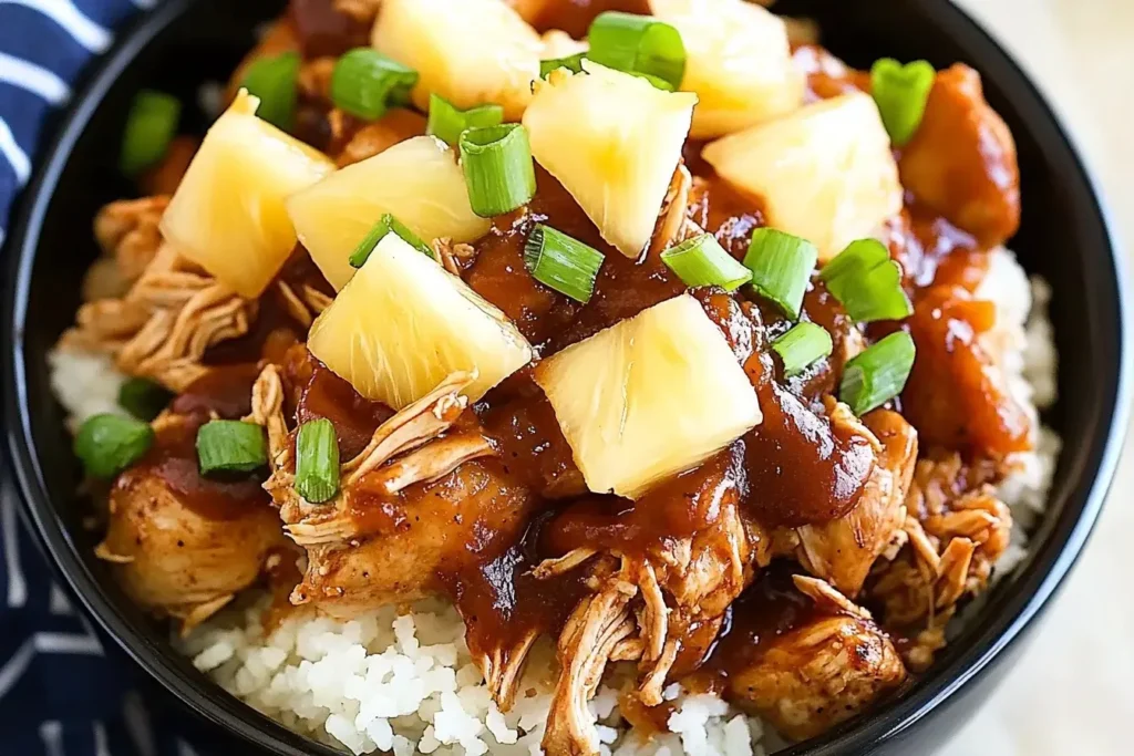 Crockpot Pineapple BBQ Chicken served over rice, topped with pineapple chunks and green onions.