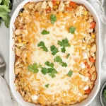 Cheesy Chicken Taco Casserole topped with fresh cilantro in a white baking dish