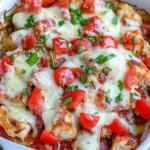 Chicken Bruschetta Casserole baked with melted mozzarella, fresh tomatoes, and basil in a white dish.