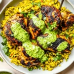 Grilled Peruvian Chicken and Rice with Green Sauce served over yellow rice and topped with creamy cilantro sauce.