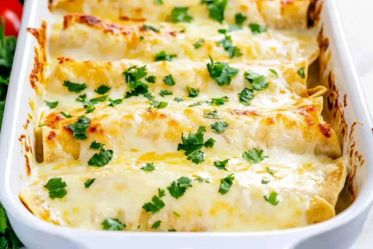 Freshly baked White Chicken Enchilada Casserole topped with melted cheese and chopped cilantro in a white casserole dish.