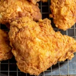 Close-up of crispy homemade Kentucky Fried Chicken resting on a wire rack