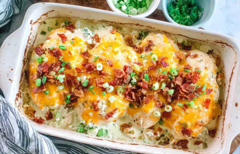 Million Dollar Chicken Bake topped with melted cheese, crispy bacon, and green onions in a white baking dish.