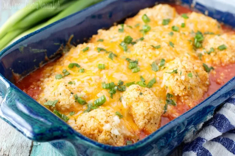 Cheddar Bay Chicken Bake fresh out of the oven, topped with melted cheese and chopped green onions in a blue casserole dish.