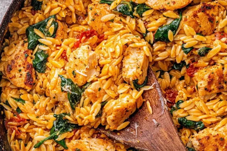 Close-up of creamy Cajun Chicken Orzo with spinach and sun-dried tomatoes