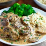 Mushroom Asiago Chicken served with broccoli and couscous on a white plate