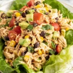 Southwest Chicken Salad served on crisp lettuce leaves with avocado, black beans, corn, and cherry tomatoes.