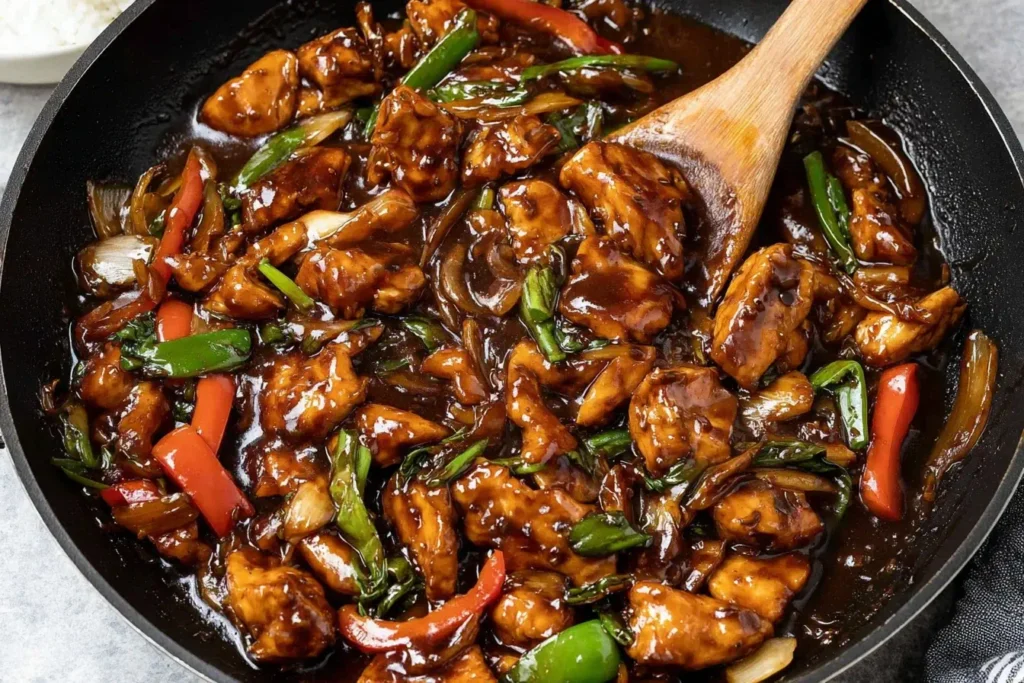 Chicken in Garlic Sauce Chinese sizzling in a pan with peppers and onions