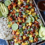 One Pan Chicken and Pineapple Tacos with juicy chicken, pineapple chunks, lime, avocado, and tortillas arranged on a baking tray