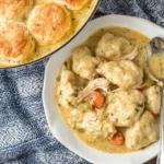 Chicken and Dumplings with biscuits served in a bowl and pot, featuring creamy sauce and vegetables