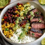 Cilantro Lime Steak Bowls featuring sliced grilled steak, white rice, corn, black beans, peppers, and cilantro lime sauce.