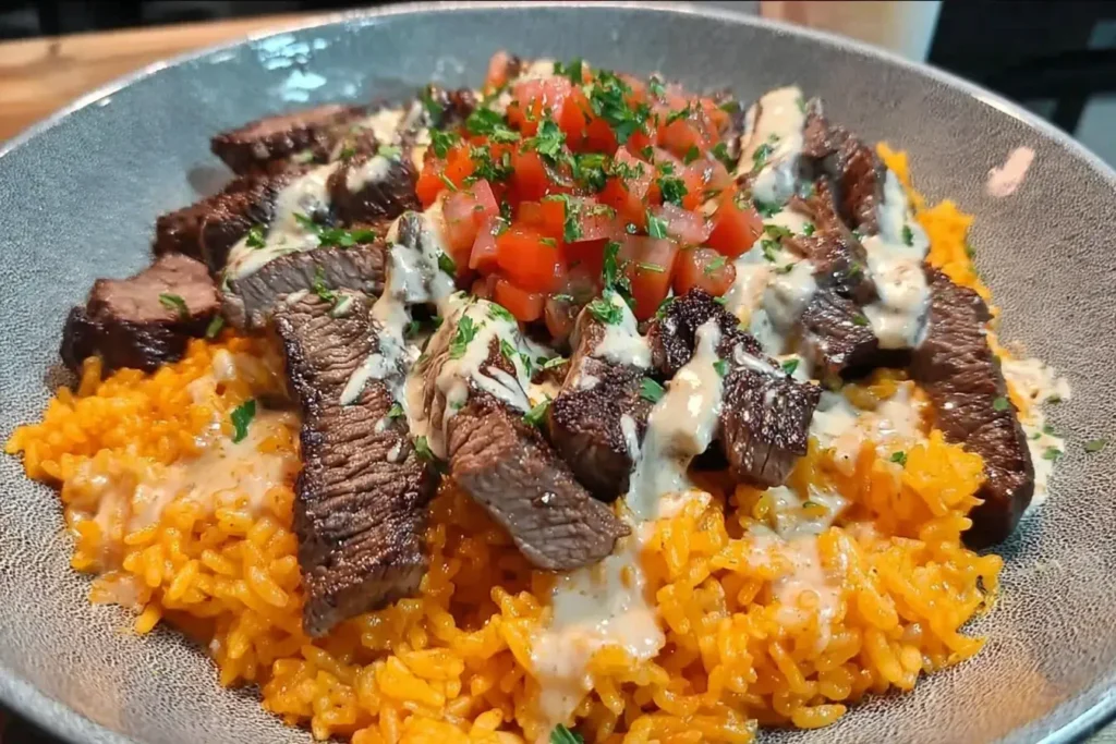 Steak Queso Rice with juicy steak strips, creamy queso sauce, and vibrant diced tomatoes over flavorful rice