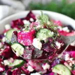 Close-up spoonful of Beet Salad with Feta Cucumbers and Dill showing vibrant beets, fresh cucumber slices, feta, and dill.