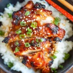 Spicy Korean Chicken served over steamed rice with sesame seeds and green onions