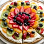 Fruit Pizza with a sugar cookie crust, cream cheese frosting, and vibrant layers of strawberries, kiwi, blueberries, raspberries, and mandarins