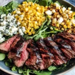 Grilled Balsamic Steak Salad with Gorgonzola, grilled corn, and fresh greens served in a round bowl.