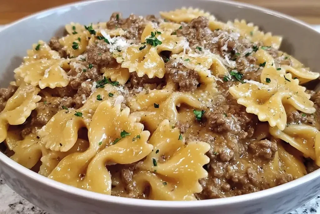 Creamy Parmesan Garlic Beef Bowtie Pasta served in a bowl with ground beef, rich sauce, and fresh parsley garnish.