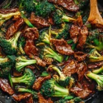 Chinese Beef and Broccoli stir-fry with tender beef slices, fresh broccoli florets, and savory sauce in a black skillet.