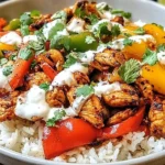 Chicken Fajita Rice Bowls with grilled chicken, colorful bell peppers, cilantro, and creamy sauce over white rice.