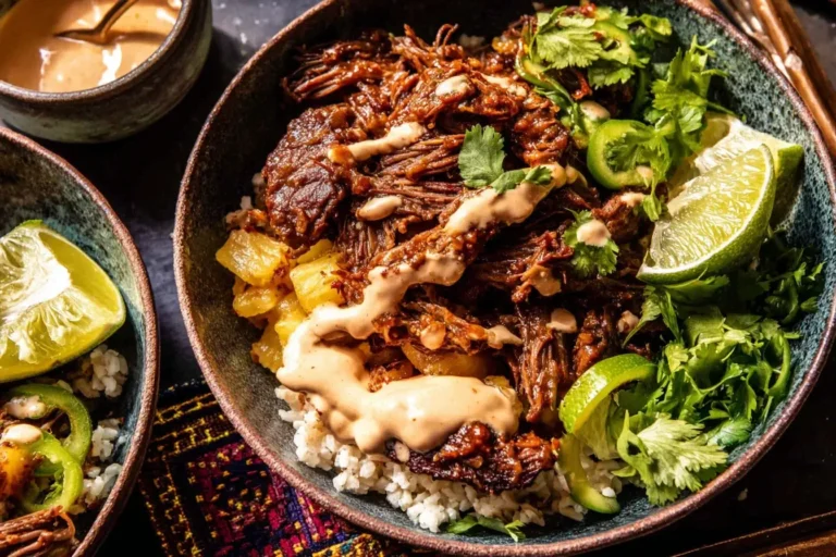 Crockpot Chipotle Pineapple Pot Roast Bowls with shredded beef, pineapple, fresh cilantro, lime, and creamy chipotle sauce over rice.