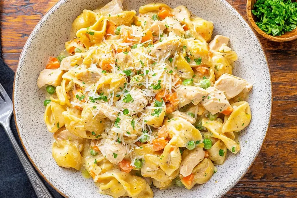 Creamy Chicken Pot Pie Pasta with tender chicken, peas, carrots, and egg noodles in a rich sauce, topped with fresh parsley and Parmesan.