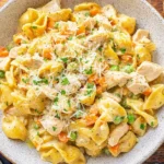 Creamy Chicken Pot Pie Pasta with tender chicken, peas, carrots, and egg noodles in a rich sauce, topped with fresh parsley and Parmesan.