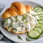 Savory Dill Pickle Chicken Salad served in a croissant with cucumber slices.