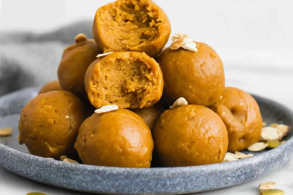 Soft pumpkin protein balls with a bite showing creamy texture