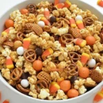 Bowl of Scarecrow Crunch Snack Mix with caramel corn, pretzels, candy corn, and festive fall candies.