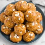 Homemade pumpkin protein balls topped with oats on a plate
