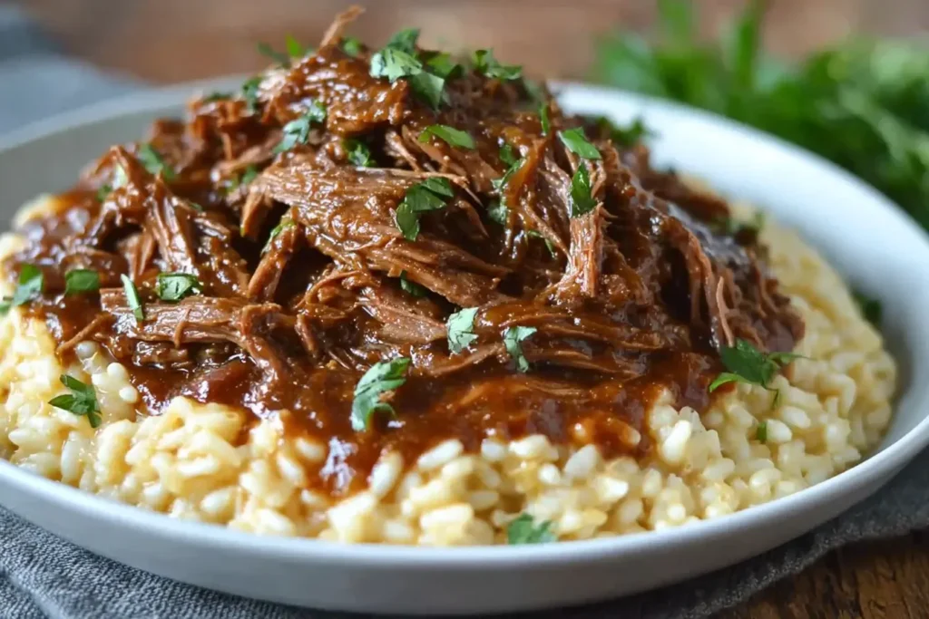 Tender Italian Pot Roast and Parmesan Risotto served on a plate, topped with rich gravy and fresh herbs for the ultimate comfort meal.