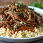 Tender Italian Pot Roast and Parmesan Risotto served on a plate, topped with rich gravy and fresh herbs for the ultimate comfort meal.