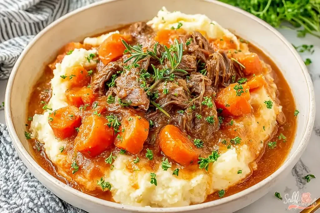 Fall Apple Cider Stew Mash with tender beef, carrots, and rosemary served over creamy mashed potatoes in a rustic bowl.