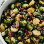 Crispy Maple Bacon Brussels Sprouts with pecans in a white bowl, a sweet and savory side dish perfect for holidays or weeknight dinners.