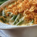 Traditional Southern Green Bean Casserole with creamy sauce and crispy fried onions in a white baking dish